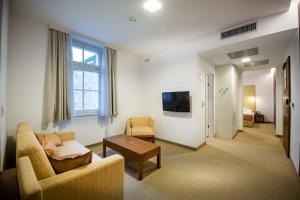 uma sala de estar com um sofá e uma mesa em Rimske Terme Resort - Hotel Zdraviliški dvor em Rimske Toplice