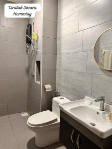 a bathroom with a toilet and a sink and a mirror at Teratak Desaru Homestay Wi-fi, Smart TV & Water Dispenser in Bandar Penawar