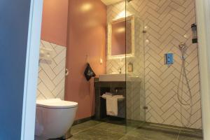 La salle de bains est pourvue de toilettes, d'un lavabo et d'un miroir. dans l'établissement Hotel Rauw aan de Kade, à IJmuiden