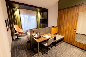 a hotel room with a desk and a table at VIA PLAZA Hotel Meppen in Meppen