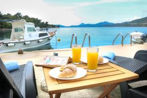 a table with two glasses of orange juice and pastries on it at Apartments Melany in Slano