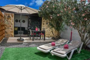 een patio met 2 bedden en een tafel met een parasol bij Mini Loft Tesa in Mácher