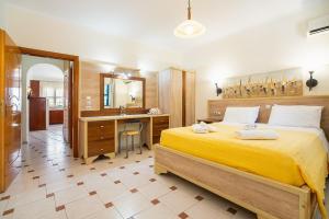 Livadia Beach Suite في Livadia: غرفة نوم بسرير اصفر كبير ومكتب