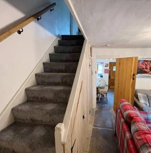 a staircase in a room with a couch and a stair case at Foresters Inn Cottage in Parkend