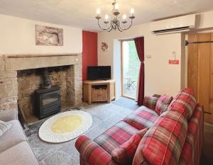 a living room with a couch and a fireplace at Foresters Inn Cottage in Parkend
