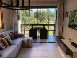 a living room with a couch and a large window at Flat no Condomínio Paraíso Serra Negra - A 200m da Bodega de Véio in Bezerros