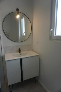 un bagno con lavandino e specchio di Riva Cottage a Saint-Aignan Altre 5 foto