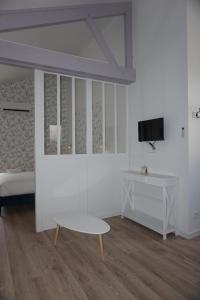 una stanza con un letto, un tavolo e una tv di Riva Cottage a Saint-Aignan