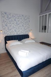 un grande letto con due cuscini bianchi sopra di Riva Cottage a Saint-Aignan