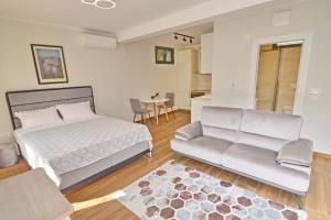 a bedroom with a bed and a couch and a table at Urban escape for two in Kotor in Kotor