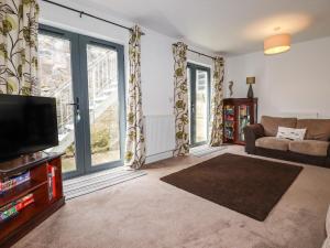 salon z telewizorem i kanapą w obiekcie Spinnaker w mieście St Austell