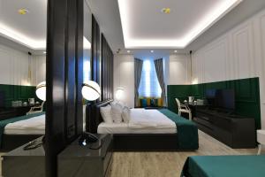 una camera d'albergo con due letti, una scrivania e una televisione di Royal Wellness and Spa a Ruma