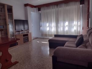 a living room with a couch and a flat screen tv at Apartamento playa de los Lances in Tarifa
