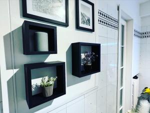 a wall with black picture frames and flowers on it at B&B Giulianova in Giulianova