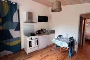 una cocina con una mesa y una estufa horno superior en T2 avec terrasse privée, en La Rochelle