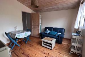 Una sala de estar con un sofá azul y una mesa. en T2 avec terrasse privée, en La Rochelle