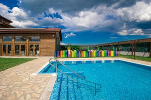 a swimming pool with a playground in front of a building at Thermal Hotel Seven Seasons in Banya