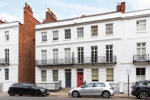 a white building with cars parked in front of it at Boutique Basement 1 Bed Flat, central location, free parking, Wi-Fi, Sky, Netflix in Leamington Spa