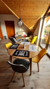 une salle à manger avec une table en bois et des chaises jaunes dans l'établissement SnežienkaD, à Vysoké Tatry