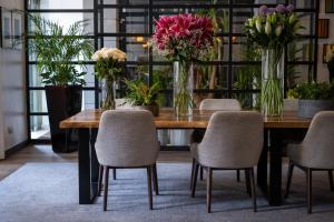 un tavolo in legno con sedie e vasi di fiori di K+K Hotel George Kensington a Londra
