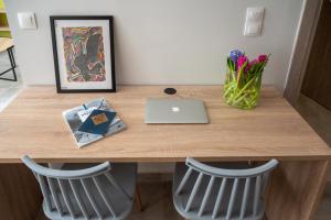 mesa de madera con ordenador portátil y 2 sillas en Koup Collection Suites, en Tesalónica