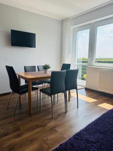 a dining room with a wooden table and chairs at Sunny Apartament in Pustkowo