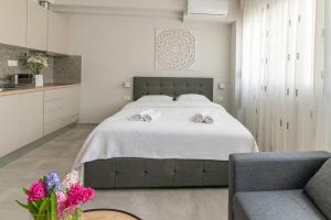 1 dormitorio con 1 cama grande y 1 silla en Koup Collection Suites, en Tesalónica