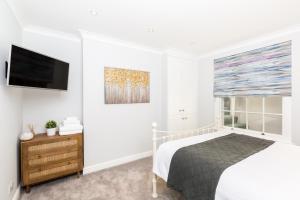 a bedroom with a bed and a flat screen tv at Boutique Basement 1 Bed Flat, central location, free parking, Wi-Fi, Sky, Netflix in Leamington Spa