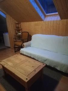 een slaapkamer met een bed en een houten tafel bij AgroDana Malinka in Wisełka