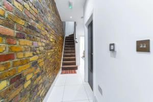 a brick wall in the hallway of a house at Spacious and Comfy 6BD House - Ilford! in Ilford