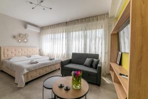 1 dormitorio con cama, sofá y mesa en Koup Collection Suites, en Tesalónica
