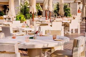 a restaurant with white tables and chairs and umbrellas at Cap d'Antibes Beach Hotel in Juan-les-Pins +37 photos