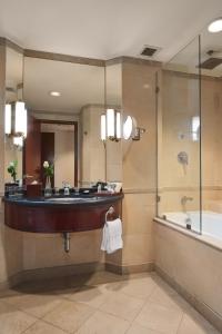 a bathroom with a sink and a tub and a mirror at Grand Nile Tower in Cairo