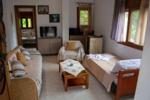 a living room with two couches and a table at Efi's Guest House in Agios Dimitrios