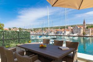 a table on a balcony with a view of a harbor at Apartment ACI Marina MILNA Brač in Milna