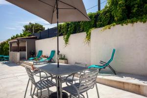 - une table et des chaises avec un parasol sur la terrasse dans l'établissement Maison de vacances, à La Ciotat
