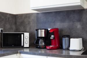 a kitchen counter with a coffee maker and a microwave at Maison de vacances in La Ciotat