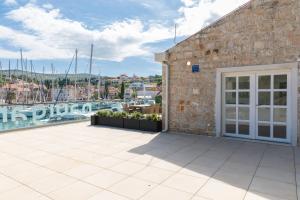 a building with a patio with a view of a marina at Apartment ACI Marina MILNA Brač in Milna