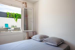 a bedroom with a bed with two pillows in front of a window at Maison de vacances in La Ciotat