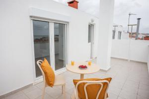 a table and chairs in a room with a balcony at One bedroom Apt in Almada - Balcony with River Views by Lisbeyond in Almada