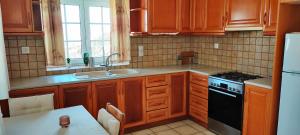 a kitchen with wooden cabinets and a black stove top oven at The Fig Tree - Deluxe Studio in Ios Chora +20 photos