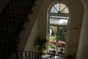 una finestra ad arco in una casa con una pianta accanto di Palazzo Manzoni Apartments a Bari