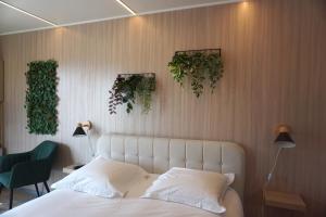 1 dormitorio con 1 cama y plantas en la pared en Riva Kub, en Saint-Aignan