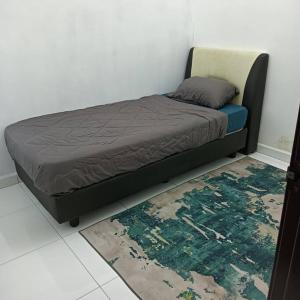 a bed in a room with a rug on the floor at Damai Homestay in Kepala Batas
