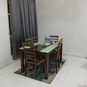 uma mesa de jantar e cadeiras com garrafas de água em Damai Homestay em Kepala Batas