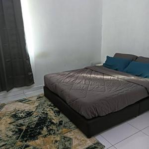 uma cama com almofadas azuis num quarto em Damai Homestay em Kepala Batas