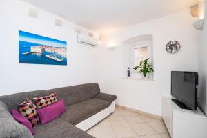 a living room with a couch and a tv at Dubrovnik Gate Apartments in Dubrovnik