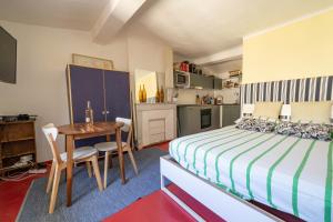 a bedroom with a bed and a table and a kitchen at Catherine Studios in Aix-en-Provence