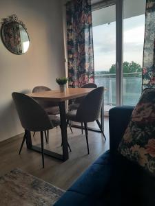 グダニスクにあるApartament Gdańsk Przymorzeのダイニングルーム(テーブル、椅子、窓付)