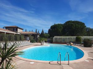 - une piscine dans une cour entourée de chaises dans l'établissement Relais du Salagou - Chalets climatisés proche Lac du Salagou, à Le Bosc